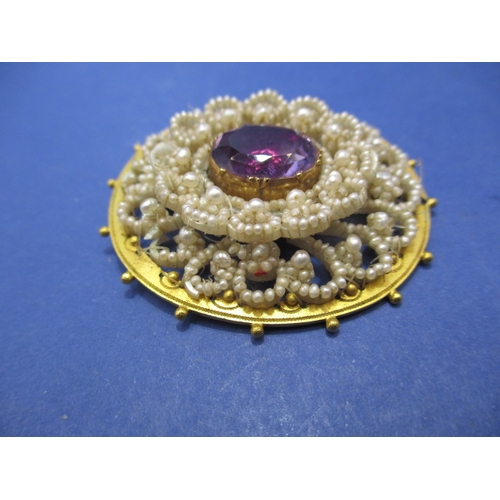 118 - An early 19th century brooch set with seed pearls and large central amethyst. Unmarked yellow metal ... 