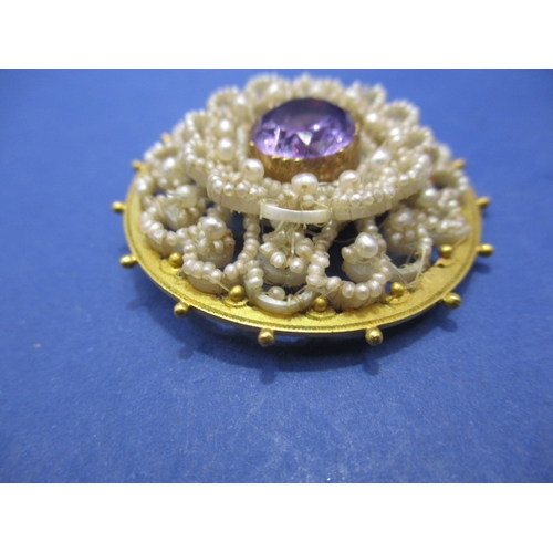 118 - An early 19th century brooch set with seed pearls and large central amethyst. Unmarked yellow metal ... 