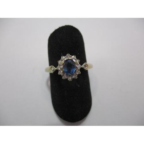 28 - A 9ct gold ring, with central Cylon sapphire, surrounded by diamonds and diamond set shoulders. Appr... 