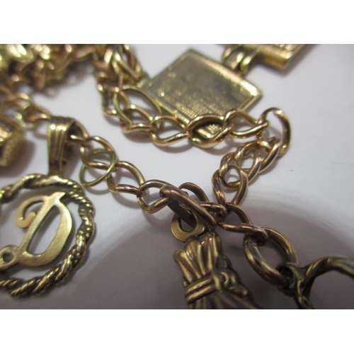 94 - A vintage gold charm bracelet, with various gold and yellow metal charms, approx. gross parcel weigh... 