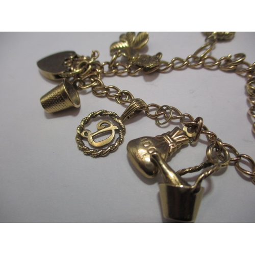 94 - A vintage gold charm bracelet, with various gold and yellow metal charms, approx. gross parcel weigh... 