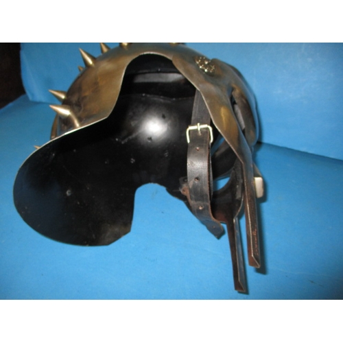 30 - A metal full size replica gladiators helmet, with leather chin strap, in useable pre-owned condition