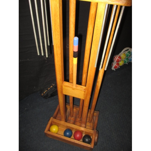 41 - A garden croquet set on wheeled wood stand, in used condition and a set of boules