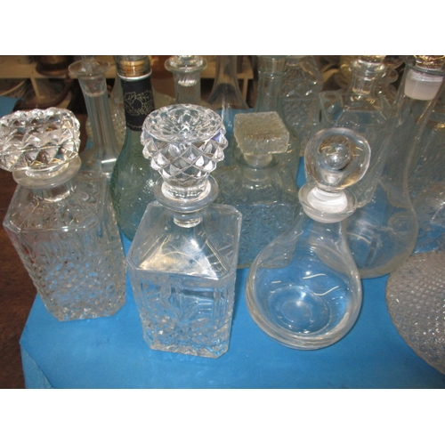 68 - A large collection of glass drinks decanters, to include lead crystal examples, one with chip to rim... 