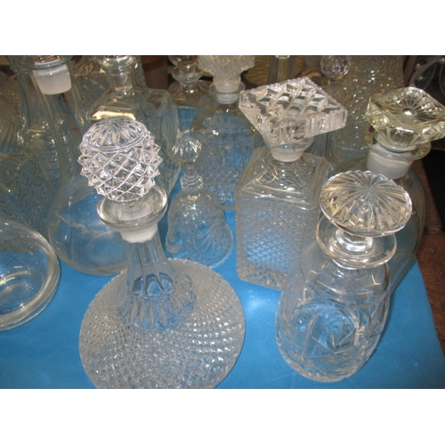 68 - A large collection of glass drinks decanters, to include lead crystal examples, one with chip to rim... 