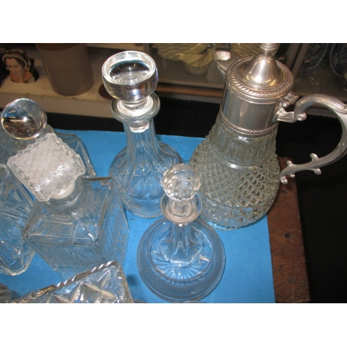 68 - A large collection of glass drinks decanters, to include lead crystal examples, one with chip to rim... 