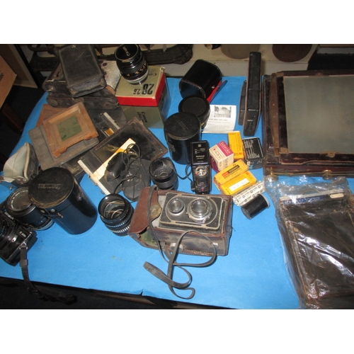 151 - A large quantity of vintage cameras and accessories, to include plate cameras and examples by Canon ... 