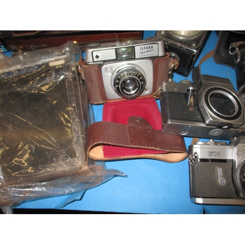 151 - A large quantity of vintage cameras and accessories, to include plate cameras and examples by Canon ... 