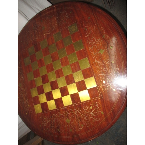 162 - A vintage circular games table with inlaid brass chess board top, approx. diameter 71cm, approx. hei... 