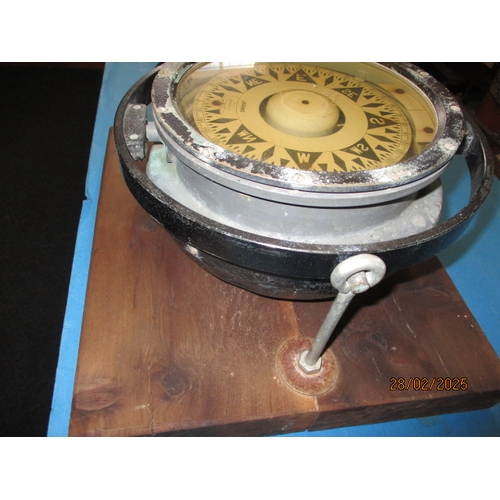 258 - A large gimble ships compass on heavy wood stand. Approximate diameter 29cm In pre-owned condition