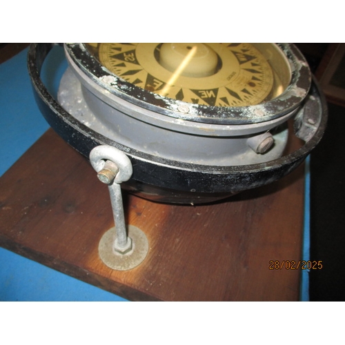 258 - A large gimble ships compass on heavy wood stand. Approximate diameter 29cm In pre-owned condition