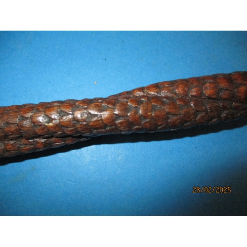 264 - A vintage walking cane, carved wood to simulate snake skin. Approximate length 90cm