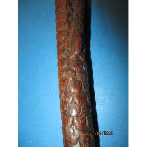 264 - A vintage walking cane, carved wood to simulate snake skin. Approximate length 90cm