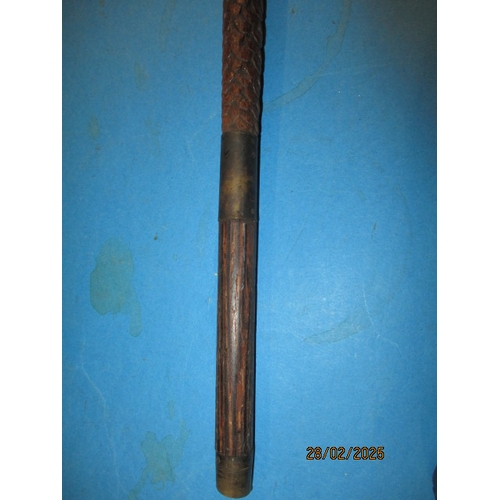 264 - A vintage walking cane, carved wood to simulate snake skin. Approximate length 90cm