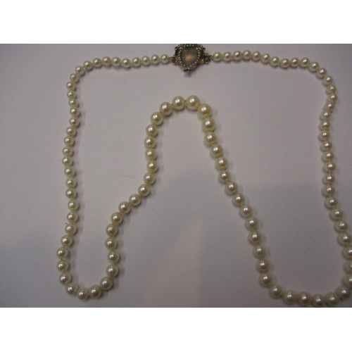 A vintage graduated pearl necklace the clasp of yellow metal set with emeralds and seed pearls, approx linear length 65cm