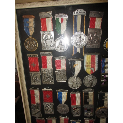272 - A framed collection of 1950’s 60’s shooting medals, one mans awards who was Switzerland’s champion m... 