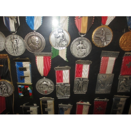 272 - A framed collection of 1950’s 60’s shooting medals, one mans awards who was Switzerland’s champion m... 