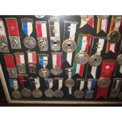 272 - A framed collection of 1950’s 60’s shooting medals, one mans awards who was Switzerland’s champion m... 