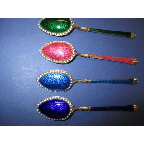 215 - A set of six 925 silver and enamel tea spoons, the pink one having the smallest sliver of enamel mis... 