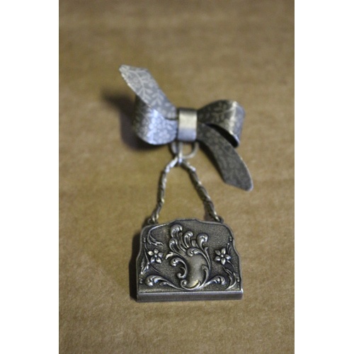 46 - Very Ornate Silver Coloured Metal - Deco Style - Bow with Hanging Handbag Brooch. The Bag Opens