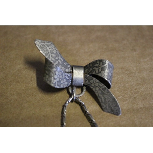 46 - Very Ornate Silver Coloured Metal - Deco Style - Bow with Hanging Handbag Brooch. The Bag Opens