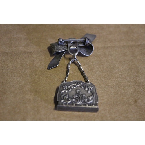 46 - Very Ornate Silver Coloured Metal - Deco Style - Bow with Hanging Handbag Brooch. The Bag Opens