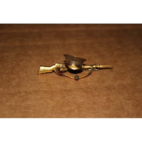 55 - Very Old Military Brooch - Gold Coloured Metal - Rifle with Cap. There are a Couple of Deep Red Ston... 