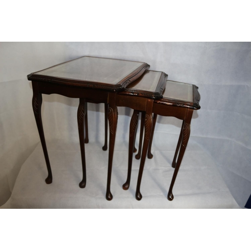 12 - Nest of three tables with carved legs, leather tops with glass over