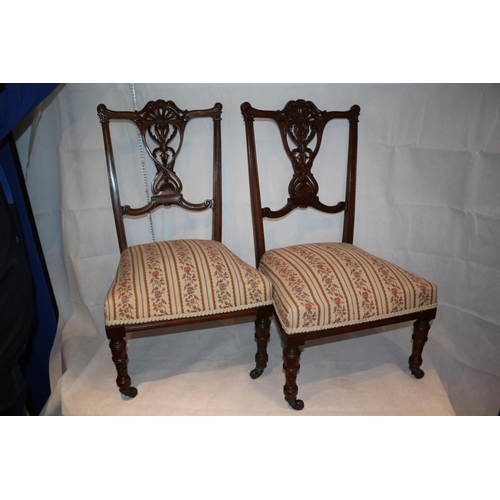 54 - Two nursery chairs with ornate carved backs complete with original casters