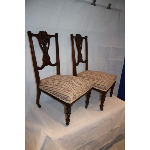 54 - Two nursery chairs with ornate carved backs complete with original casters