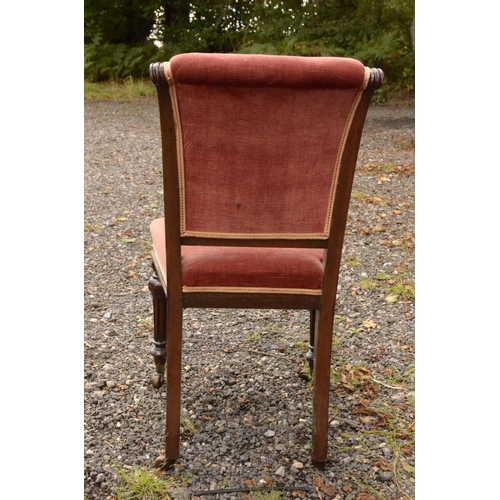 16 - A pink Velour fabric bedroom chair with ornate carved front legs on casters