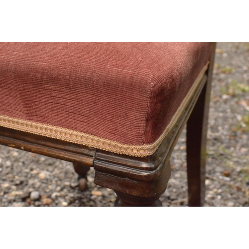 16 - A pink Velour fabric bedroom chair with ornate carved front legs on casters