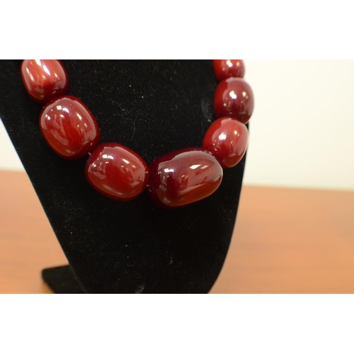 27 - A Very large Cherry Amber Coloured Bead Necklace Largest Bead 4cm 50cm Overall Length 205gms 1040