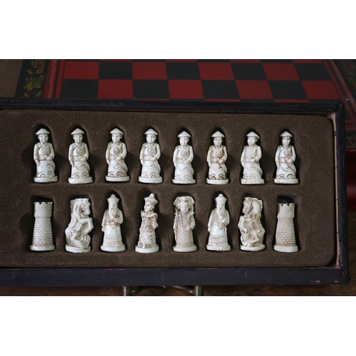 556 - Chinese Resin Chess Pieces Housed in an Ornate Twin Drawer Lacquered Chess Box - 28 x 27cm