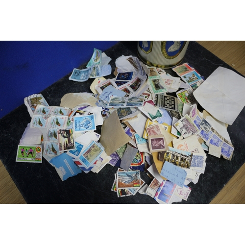 18 - TIN CONTAINING BUNDLE OF STAMPS