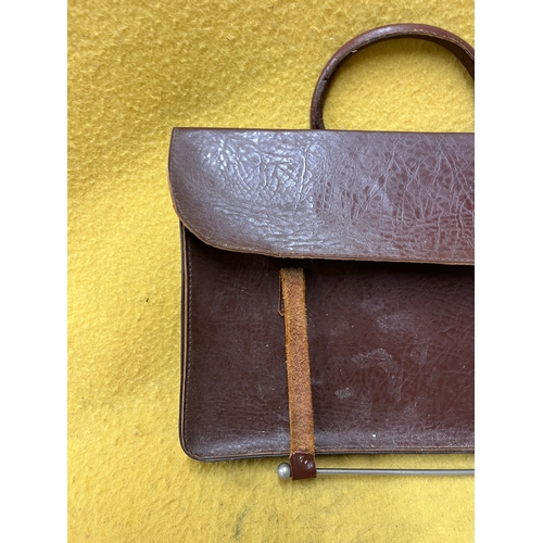 547 - Vintage leather satchel with hook over securing metal bar