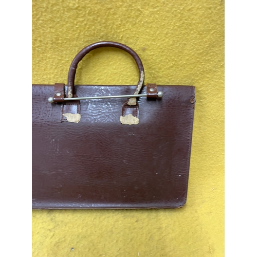 547 - Vintage leather satchel with hook over securing metal bar