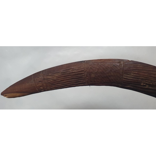 63 - An antique Aboriginal boomerang, carved to one side with linear designs, 16.75