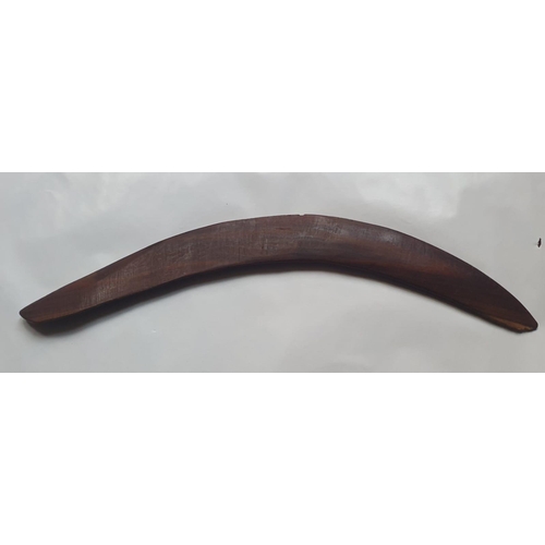 63 - An antique Aboriginal boomerang, carved to one side with linear designs, 16.75