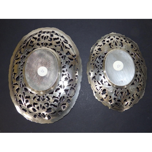 143 - Two matching Dutch silver openwork oval stands, decorated birds & flower scroll, the larger 8