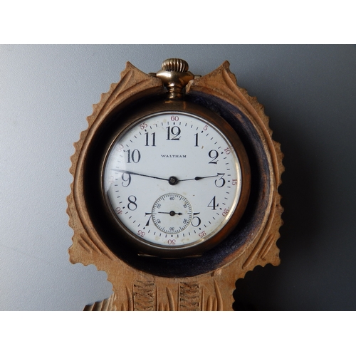 149 - A gold plated Waltham open faced pocket watch with subsidiary seconds in a folding carved wooden sta... 