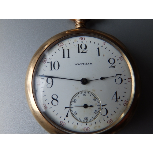 149 - A gold plated Waltham open faced pocket watch with subsidiary seconds in a folding carved wooden sta... 