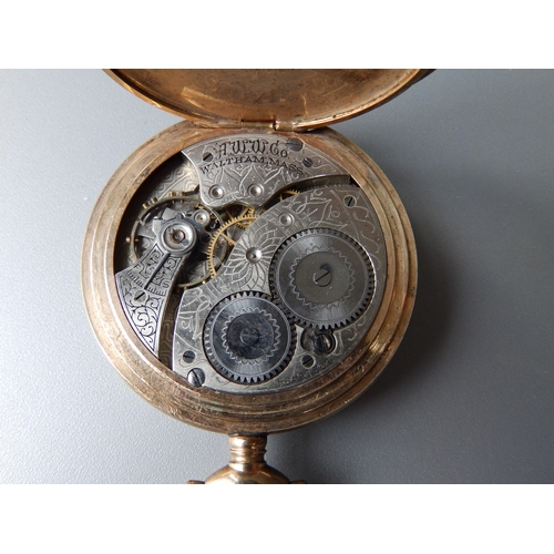 149 - A gold plated Waltham open faced pocket watch with subsidiary seconds in a folding carved wooden sta... 