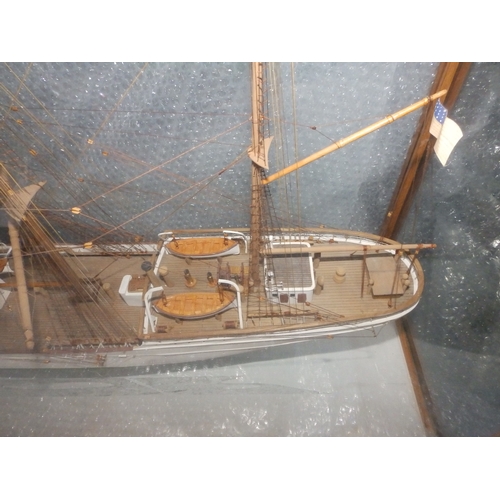 60a - A painted wooden model in glazed display case of the USCGC Barque Eagle, on mahogany stand with roun... 