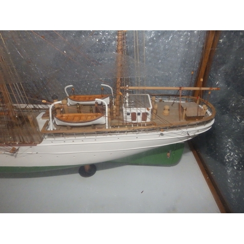 60a - A painted wooden model in glazed display case of the USCGC Barque Eagle, on mahogany stand with roun... 