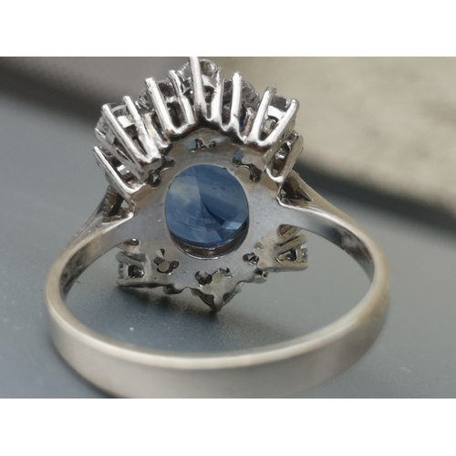 200 - A modern sapphire & diamond set cluster ring, the oval claw set sapphire weighing approximately 4 ca... 