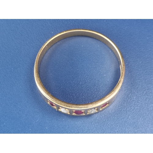 201 - An 18ct gold band ring set with two small rose cut diamonds and three rubies.  Finger size N.