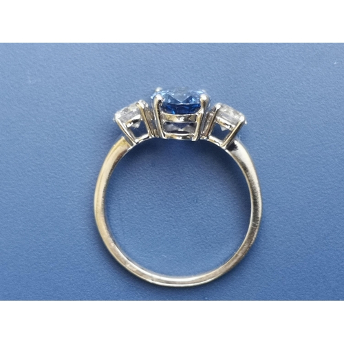 210 - A three stone sapphire & diamond ring, the four-claw set cushion cut sapphire weighing approximately... 