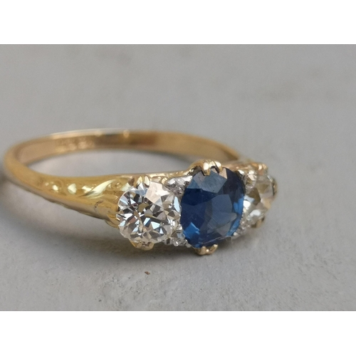 207 - A sapphire & diamond three stone ring, the central oval claw-set sapphire flanked by two old cut dia... 