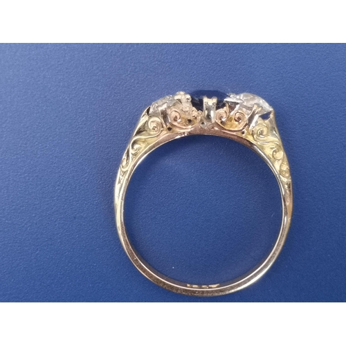 207 - A sapphire & diamond three stone ring, the central oval claw-set sapphire flanked by two old cut dia... 